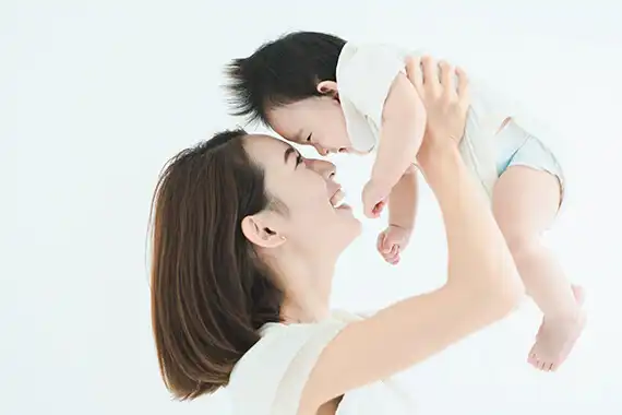 子どもを持ち上げる母親